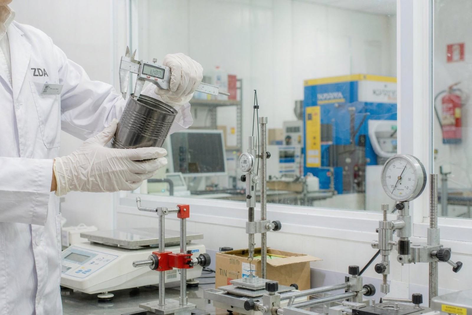 Quality control technician inspecting tinplate cans in the ZDA laboratory